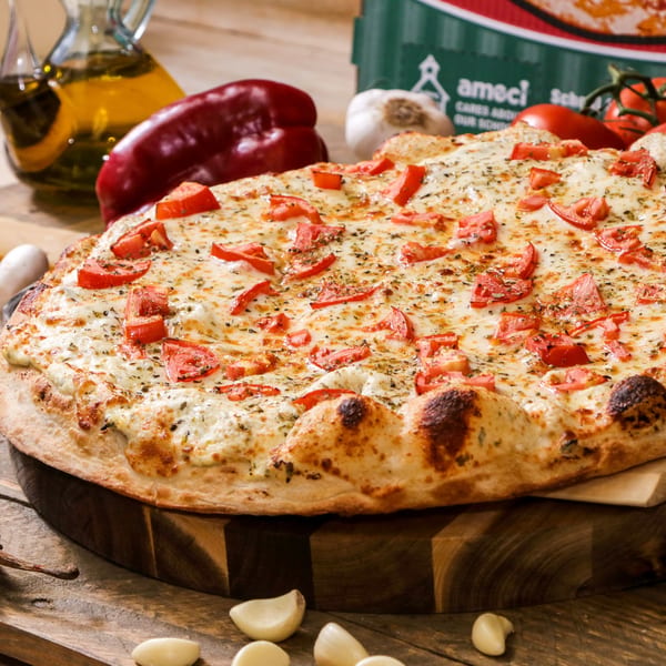 Ameci Pizza & Pasta's white pizza with diced tomatoes, herbs, and garlic on a wooden board.